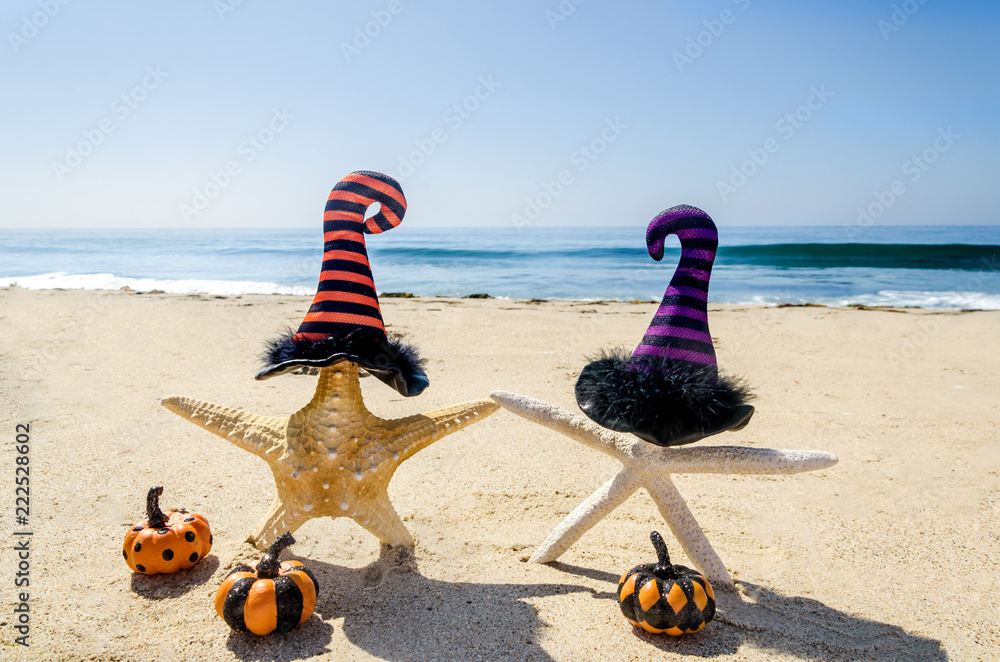 Obraz premium Halloween background on the beach with starfishes in witch's hats