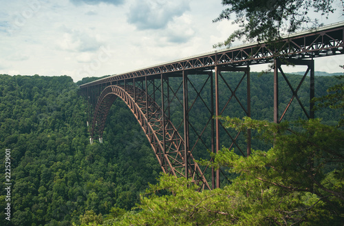 A view of the steel metal arch bridge over the New River Gorge in Fayetteville, West Virginia. The bridge is the longest steel span in the western hemisphere. Repeating lines. Horizontal image.