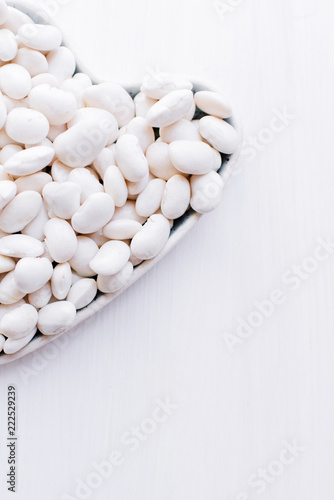 Art heart from a string bean on a wooden light background symbolizing a healthy diet