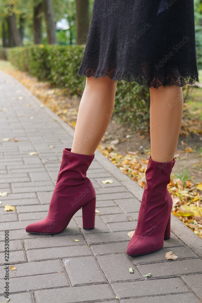 Female legs in knitted warm dress and velvet boots Female legs in knitted warm dress and velvet boots
