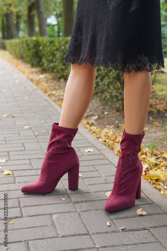 Female legs in knitted warm dress and velvet boots