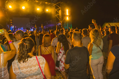 The party, concert concept. Crowd raising their hands and enjoying great rock festival. blur bokeh for background.