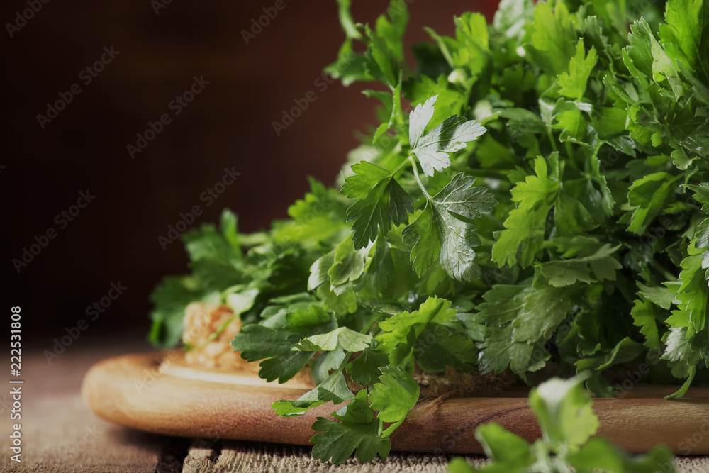 Fresh green parsley in bunch, old wooden table, selective focus