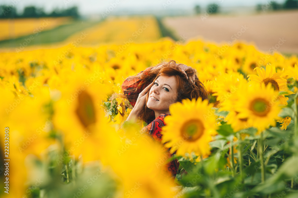 Young beautiful woman in a dress among blooming sunflowers. Agroculture. Young beautiful woman in a dress among blooming sunflowers. Agroculture.