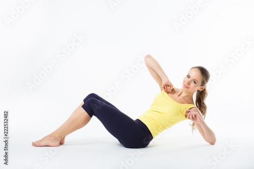 Woman exercising photographed in the white background.