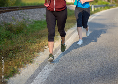 Fototapeta Naklejka Na Ścianę i Meble -  women jogging along a country road