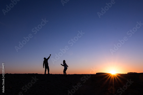 silhouette of man and woman at sunset dancing