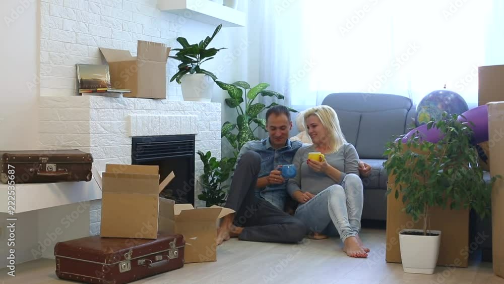Portrait of young couple moving in new home sitting with cup Portrait of young couple moving in new home sitting with cup