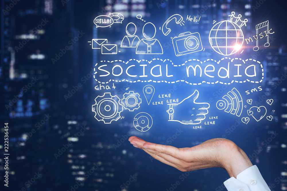 Man hand holds social media icons over night city Man hand holds social media icons over night city