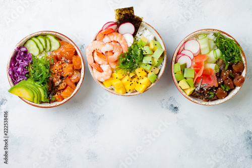 Obraz na plátně Hawaiian salmon, tuna and shrimp poke bowls with seaweed, avocado, mango, pickled ginger, sesame seeds