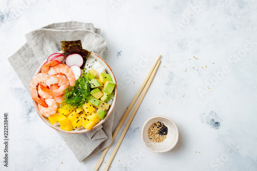 Hawaiian shrimp poke bowl with seaweed, avocado, mango, radish, sesame seeds. Top view, overhead, flat lay, copy space photo