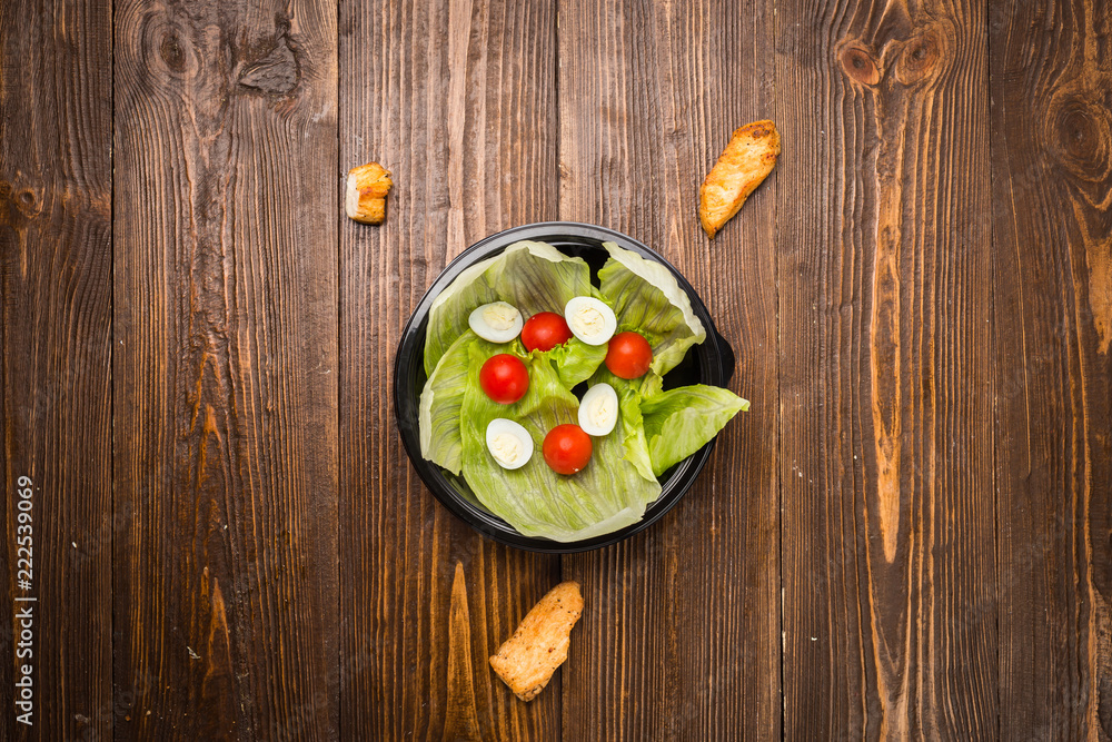 Caesar salad with chicken, cherry tomatoes and quail eggs on a plate Caesar salad with chicken, cherry tomatoes and quail eggs on a plate