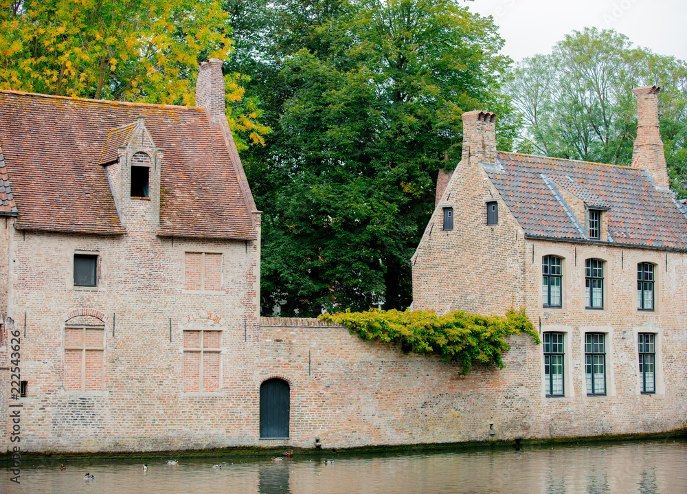 Old medieval houses near a river, fall season. Bruges, Belgium Old medieval houses near a river, fall season. Bruges, Belgium
