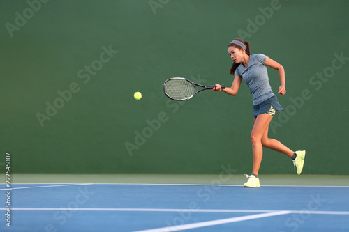 Tennis player man banner hitting ball with racket on green horizontal copy space background. Sports athlete training forehand grip technique on outdoor court. © Maridav