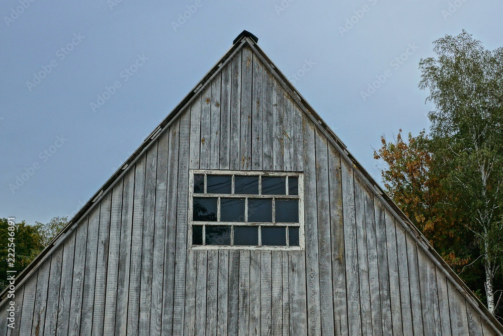 old gray wooden loft with window on the sky background