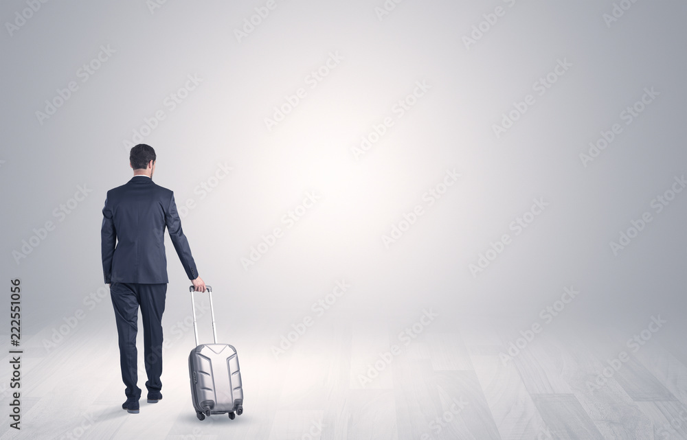 Young businessman in a white boundless space walking with back and luggage on his hand Young businessman in a white boundless space walking with back and luggage on his hand