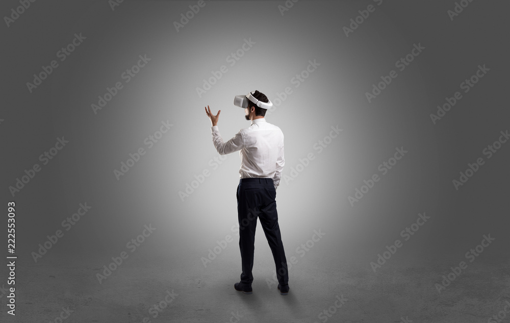 Businessman wearing vj glasse in an empty room with no wallpaper Businessman wearing vj glasse in an empty room with no wallpaper