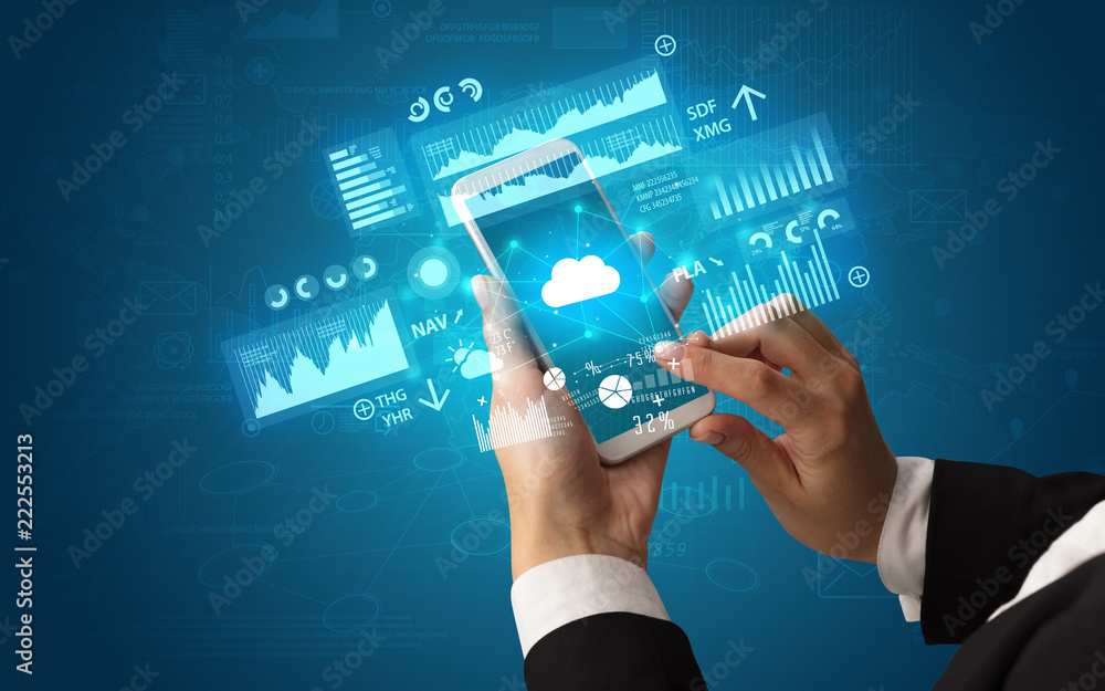 Female hand using smartphone with financial tracking concept illustrated by graphs and symbols Female hand using smartphone with financial tracking concept illustrated by graphs and symbols