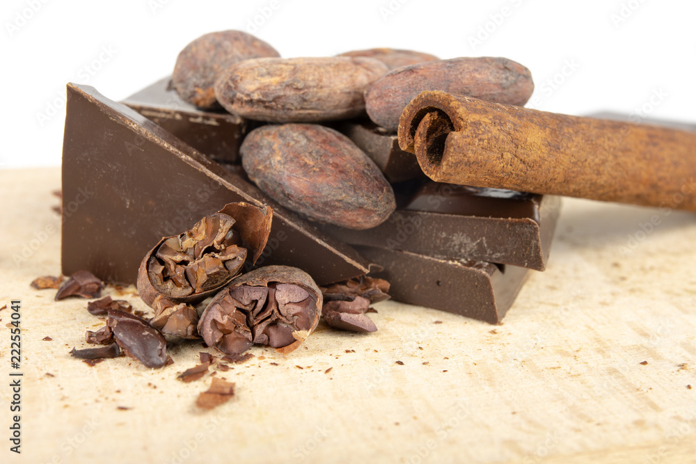 Tasty dark chocolate and cocoa beans on a white table. Sweets used to prepare desserts in the kitchen. Tasty dark chocolate and cocoa beans on a white table. Sweets used to prepare desserts in the kitchen.