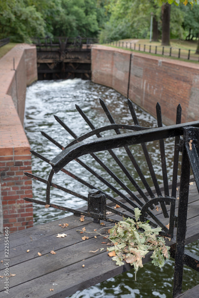 Old sluice on the channel in Central Europe. A wooden dam on the river.