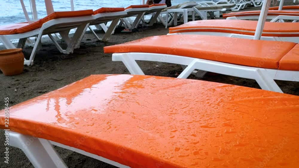 4k video of rain drops falling on empty sunbeds at sea beach 4k video of rain drops falling on empty sunbeds at sea beach