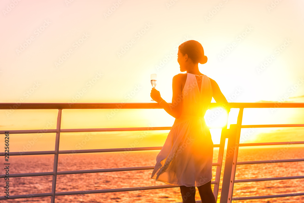 Luxury cruise ship travel elegant woman drinking glass of champagne enjoying watching sunset from boat deck over ocean in Europe destination vacation. Cruising sailing away on holiday. - obrazy, fototapety, plakaty 
