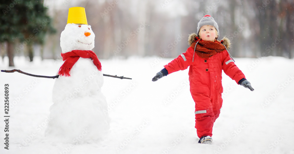 Kid during stroll in a snowy winter park