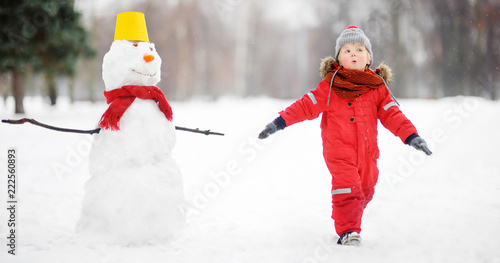 Kid during stroll in a snowy winter park
