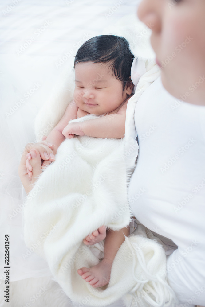 Happy beautiful asian woman looking at her sleeping baby child Happy beautiful asian woman looking at her sleeping baby child