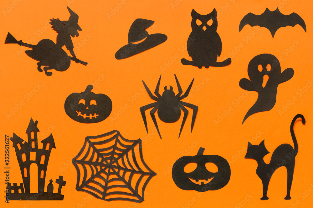 Fototapeta premium Happy Halloween Set cut out of black paper silhouettes pumpkin, witch, ghost, cat, owl, spider, web, hat, bat, castle on orange background. Concept Paper cut style. Top view