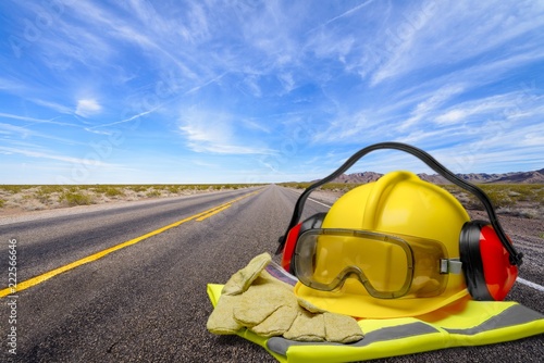 Builder staff laying on asphalt witgh blurred street on photo