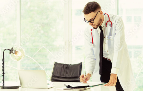 Young man doctor working at office in hospital. photo