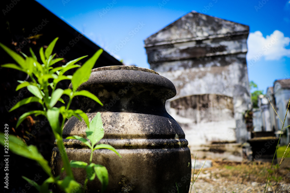 General angled view of old antique cemetery with raised crumbling sepulchers and blue skies General angled view of old antique cemetery with raised crumbling sepulchers and blue skies