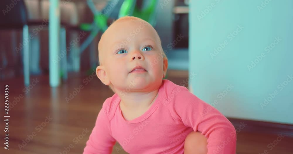 Portrait of a smiling cute little girl sitting on the floor of a house in a room Portrait of a smiling cute little girl sitting on the floor of a house in a room