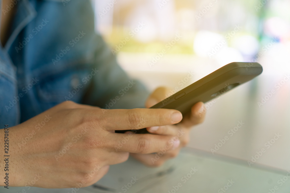 Woman hand using smartphone or tablet to do business, financial or trading stock forex market in park outdoor nature road background.