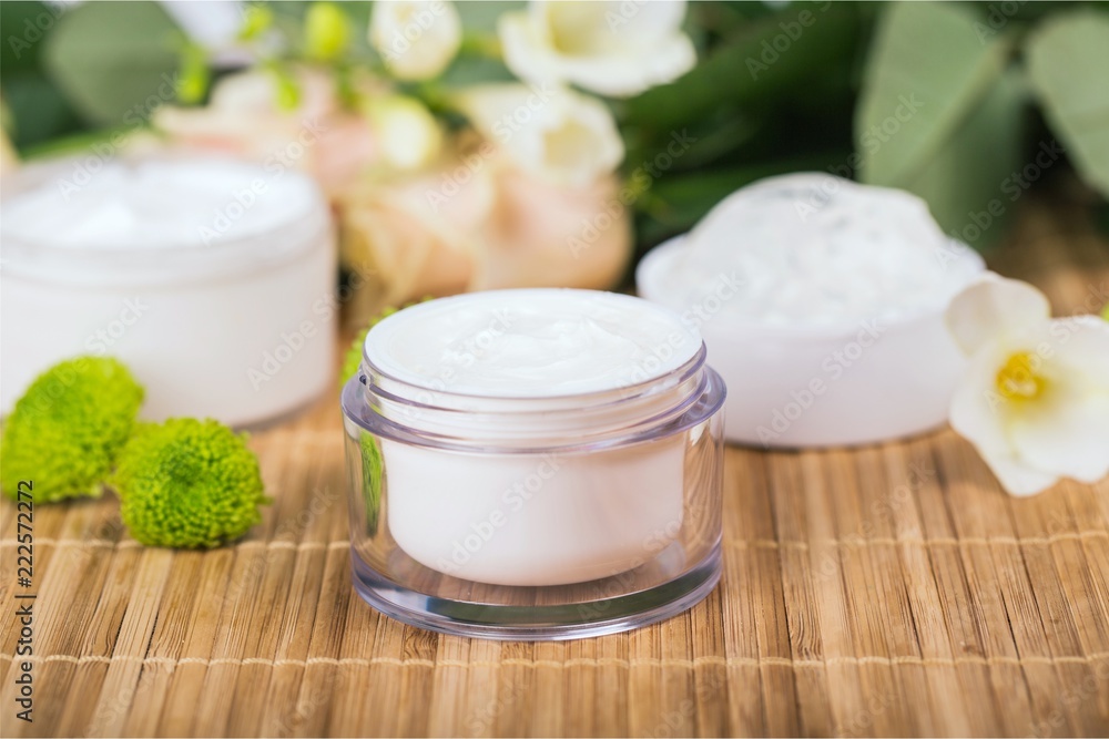 Cosmetic cream with white flowers on table Cosmetic cream with white flowers on table