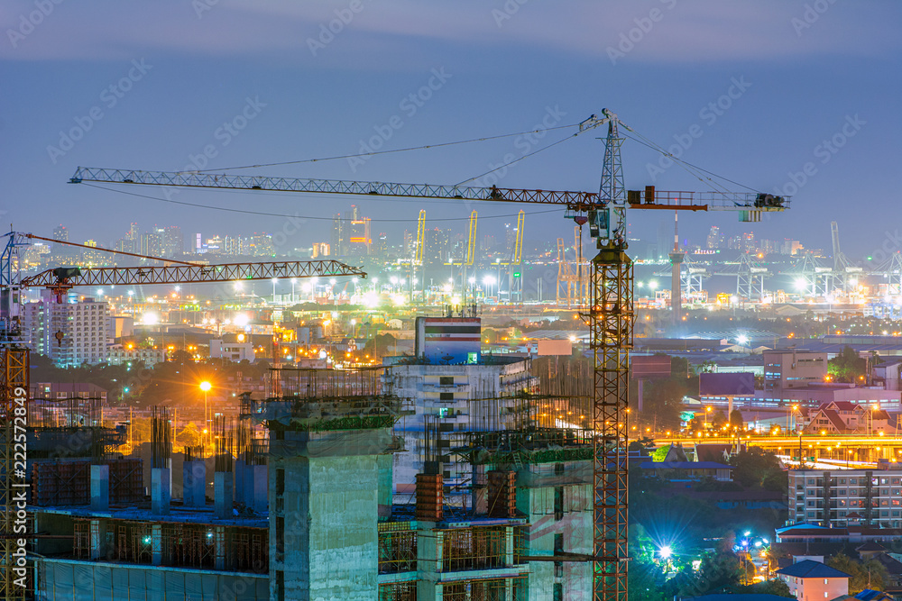 Building under construction with crane at night.