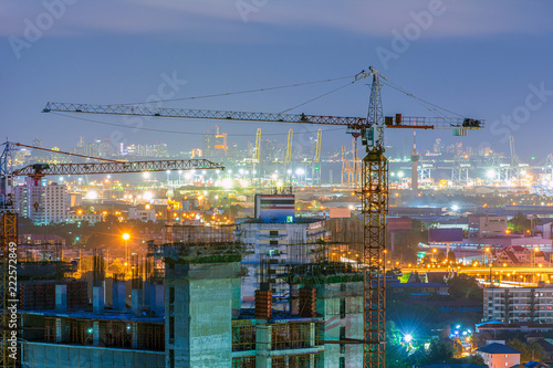 Building under construction with crane at night.