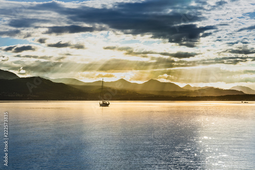 Beautiful landscape with bluee sky over the ocean and boat at sunset sunrays