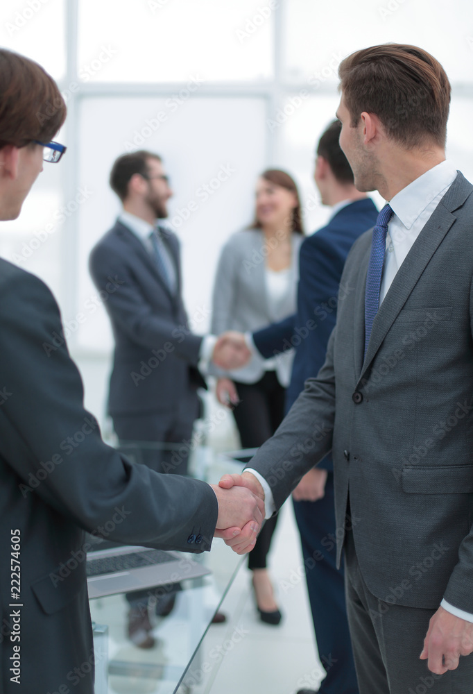 Two businessmen handshaking, congratulating on promotion. Two businessmen handshaking, congratulating on promotion.