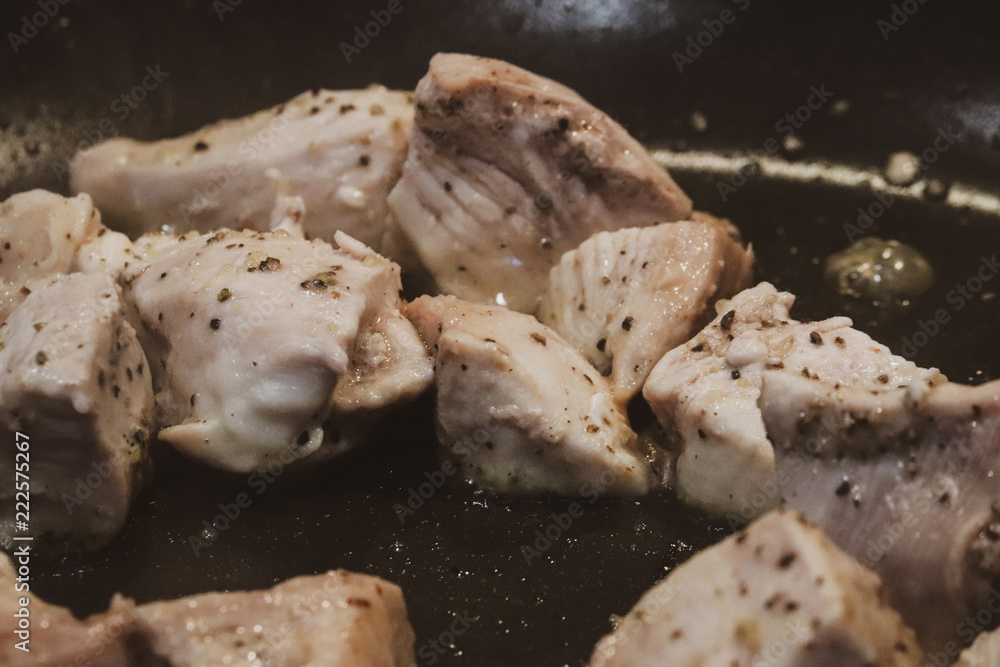 Close up view of seasoned grilling chicken within a skillet Close up view of seasoned grilling chicken within a skillet