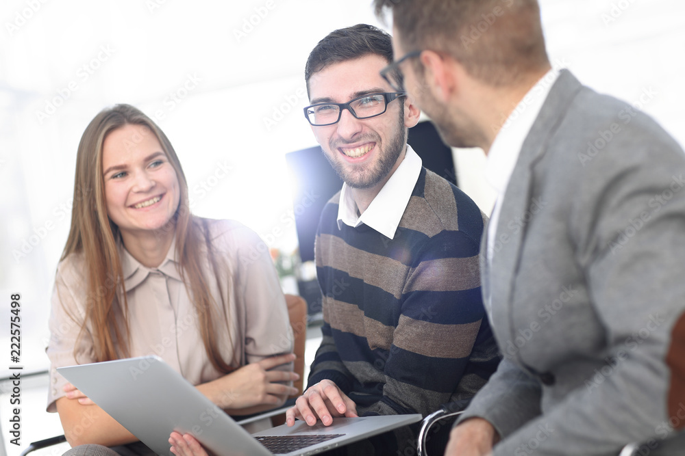 Fototapeta premium Three happy employees working on line with a tablet