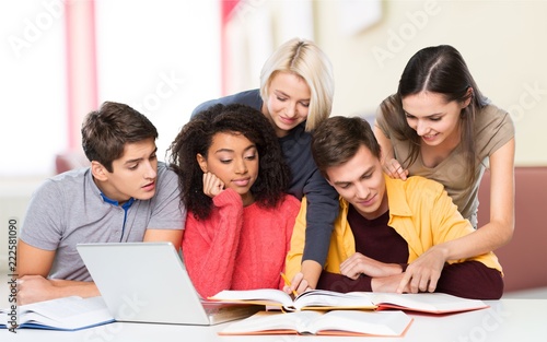 Group of students with laptop and book doing  lessons