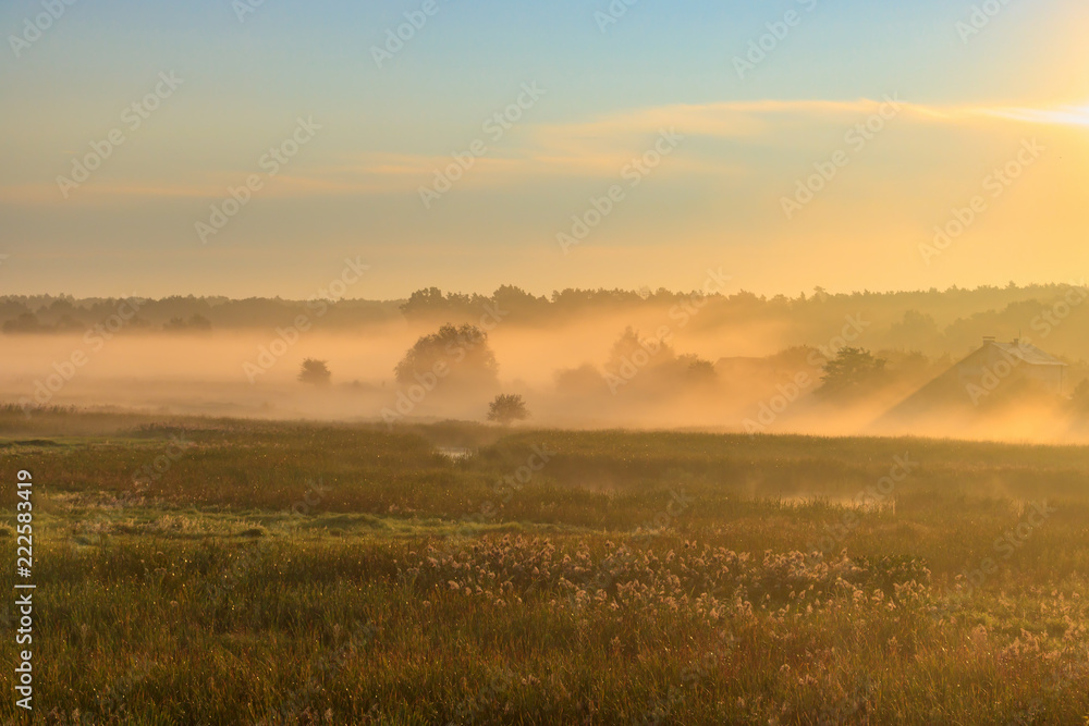 Fog over village houses in orange rays of rising sun in autumn morning. Nature landscape Fog over village houses in orange rays of rising sun in autumn morning. Nature landscape