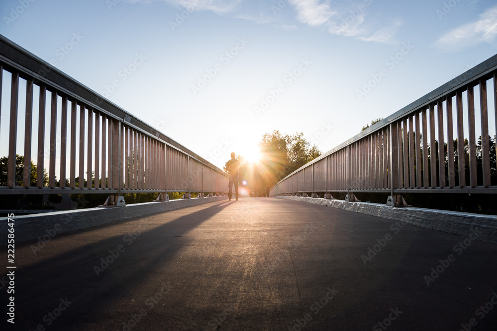 Urbane Brücke: Sonnenuntergang, Asphalt, Geländer und blauer Himmel