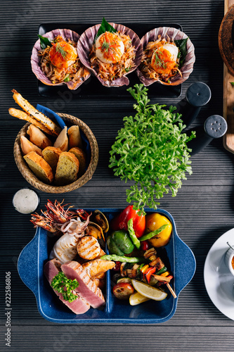 Top view of Seafood mixed grilled such as fish, squid, prawns, mussels and vegetables served with sweet and sour sauces.