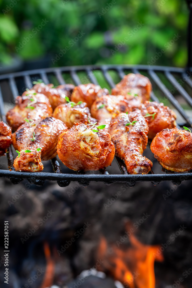 Delicious chicken leg on grill with spices and herbs