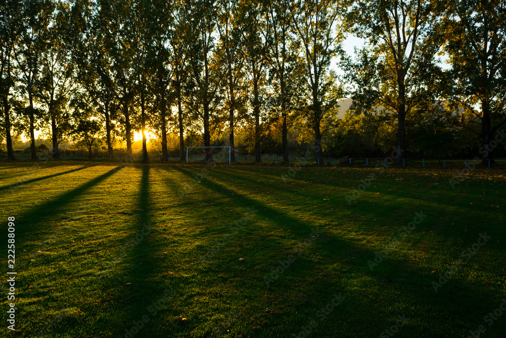 empty football ground at countryside, autumn sunset