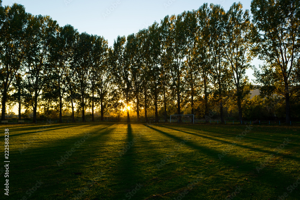 empty football ground at countryside, autumn sunset