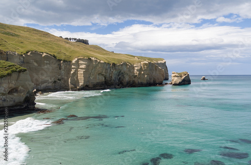 Elevated view of the cliffs and headland at Tunnel Beach on a sunny, summer's day. Otago, New Zealand.
